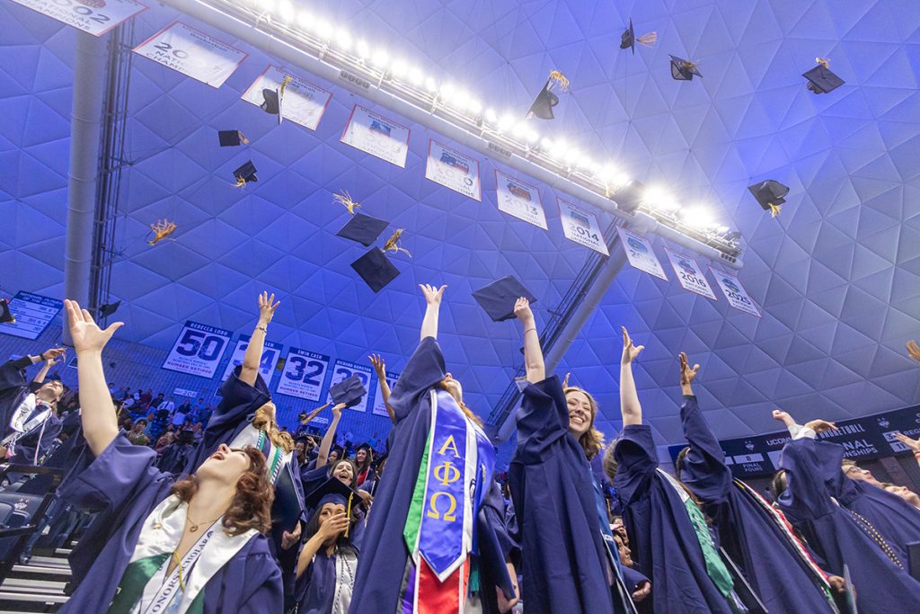 Graduates throw their caps in the air.