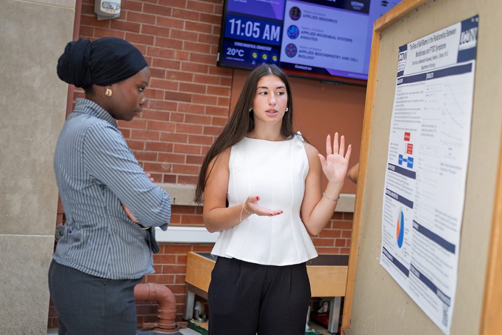 A student presenting their research poster.